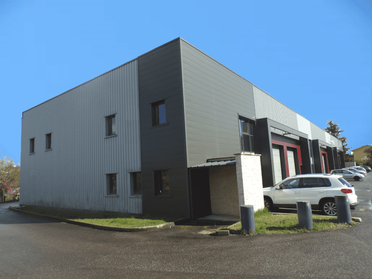 Locaux de Technett : un grand bâtiment gris, moderne et spacieux.