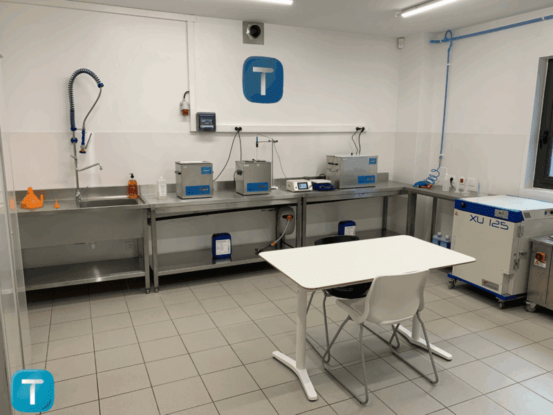 Une salle de laboratoire avec différents outils, et le logo de Technett sur le tableau blanc du fond de la pièce.